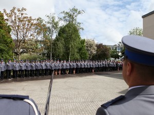 Kadra kierownicza wielkopolskiej Policji, po bokach głowy dwóch policjantów.