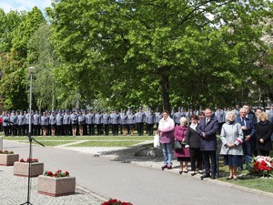 Uroczystości pod pomnikiem. Z przodu osoby ze stowarzyszeń rodzin policyjnych, w tle kadra kierownicza województwa wielkopolskiego.