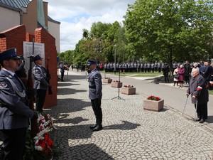 Mężczyzna o kulach oddaje hołd pomordowanym.