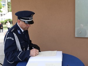 Dyrektor Biura Historii i Tradycji wpisuje się do księgi pamiątkowej.
