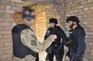 Instruktor szkolenia tłumaczy coś dwum policjantom
