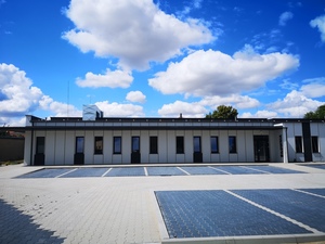 Budynek nowej białej strzelnicy, w tle niebieskie niebo.