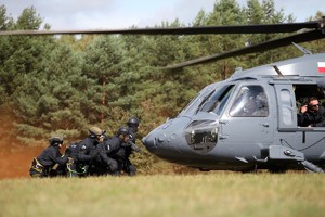 Lądujący helikopter i policjanci go przyjmujący