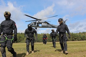 Policyjni zamaskowani kontrterroryści i Black Hawk w tle