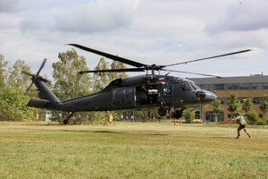 Lądujący helikopter i policjant go przyjmujący