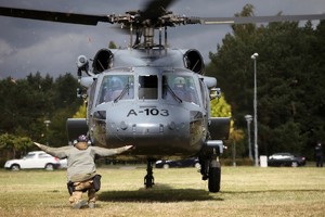 Lądujący helikopter i policjant go przyjmujący