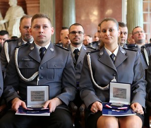 zbliżenie na policjanta i policjantkę z odznaczeniem