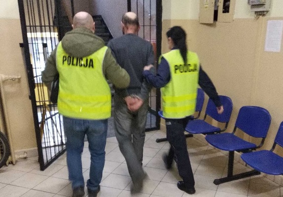 Policjanci prowadzą zatrzymanego mężczyznę