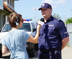 Mł. insp. Arkadiusz Sylwestrzak udziela wywiadu dziennikarce Radia Olsztyn