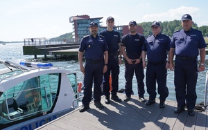 Grupowe zdjęcie Komendanta Wojewódzkiego Policji w Olsztynie z policyjnymi wodniakami oraz Komendantem Komisariatu Policji w Mikołajkach