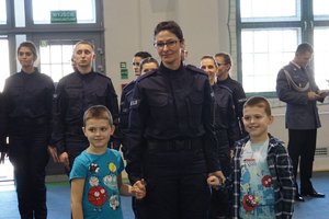 Nowi policjanci z rodzinami po uroczystym ślubowaniu