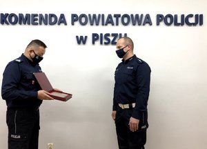 Komendant wręcza wyróżnienie policjantowi z Pisza