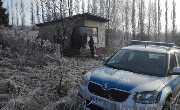 Radiowóz na zmrożonej łące obok pustostanu