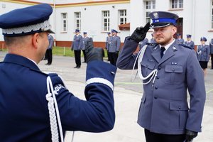Policjant odbierający akt mianowania od nadinsp. Tomasza Klimka