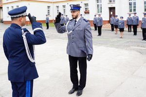 Policjant odbierający akt mianowania od nadinsp. Tomasza Klimka