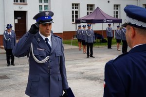 Policjant odbierający akt mianowania od nadinsp. Tomasza Klimka