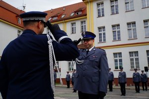 Policjant odbierający akt mianowania od nadinsp. Tomasza Klimka