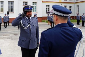 Policjant odbierający akt mianowania od nadinsp. Tomasza Klimka