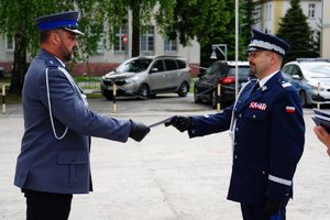 Policjant odbierający akt mianowania od nadinsp. Tomasza Klimka