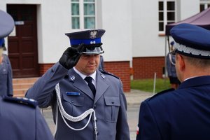 Policjant odbierający akt mianowania od nadinsp. Tomasza Klimka