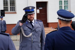 Policjant odbierający akt mianowania od nadinsp. Tomasza Klimka