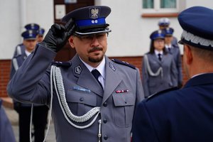 Policjant odbierający akt mianowania od nadinsp. Tomasza Klimka