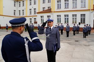 Policjant odbierający akt mianowania od nadinsp. Tomasza Klimka