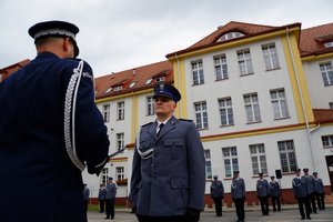 Policjant odbierający akt mianowania od nadinsp. Tomasza Klimka