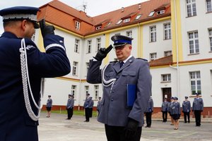 Policjant odbierający akt mianowania od nadinsp. Tomasza Klimka