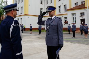 Policjant odbierający akt mianowania od nadinsp. Tomasza Klimka