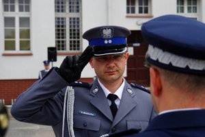 Policjant odbierający akt mianowania od nadinsp. Tomasza Klimka