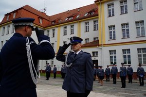 Policjant odbierający akt mianowania od nadinsp. Tomasza Klimka