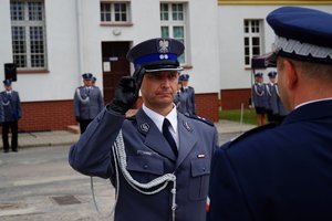 Policjant odbierający akt mianowania od nadinsp. Tomasza Klimka