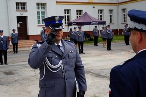 Policjant odbierający akt mianowania od nadinsp. Tomasza Klimka