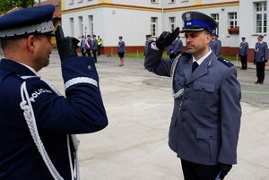 Policjant odbierający akt mianowania od nadinsp. Tomasza Klimka