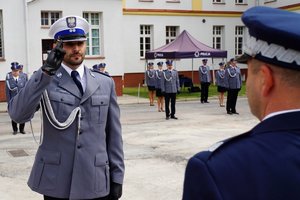 Policjant odbierający akt mianowania od nadinsp. Tomasza Klimka