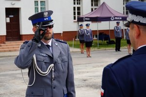 Policjant odbierający akt mianowania od nadinsp. Tomasza Klimka