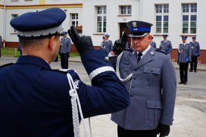 Policjant odbierający akt mianowania od nadinsp. Tomasza Klimka