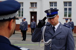Policjant odbierający akt mianowania od nadinsp. Tomasza Klimka