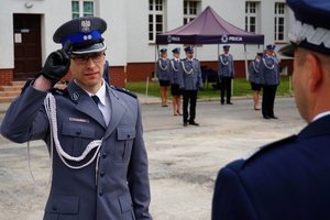 Policjant odbierający akt mianowania od nadinsp. Tomasza Klimka