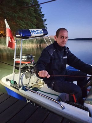 Policjant podczas zajęć praktycznych w łodzi na jeziorze