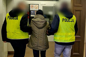 Zatrzymana kobieta prowadzona przez policjantów