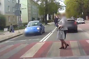 Zrzut ekranu z wideorejestratora, na którym widać moment, gdy piesza na przejściu dla pieszych, która zatrzymała się przed nadjeżdżającym autem.