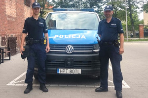 Policjanci stojący przed radiowozem