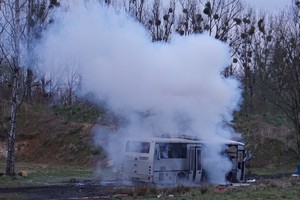 Neutralizacja niewybuchu przy autobusie. Dym unoszący się obok autobusu