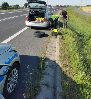 Policjanci pomagają wymienić koło w aucie