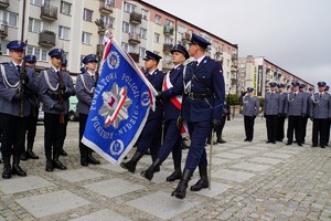 Prezentacja sztandaru. Policjanci idący paradnie ze sztandarem