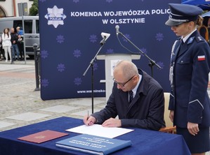 Podsekretarz Stanu MSWiA składa podpis w księdze pamiątkowej