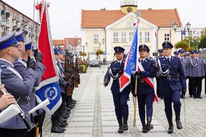 Policjanci maszerujący ze sztandarem