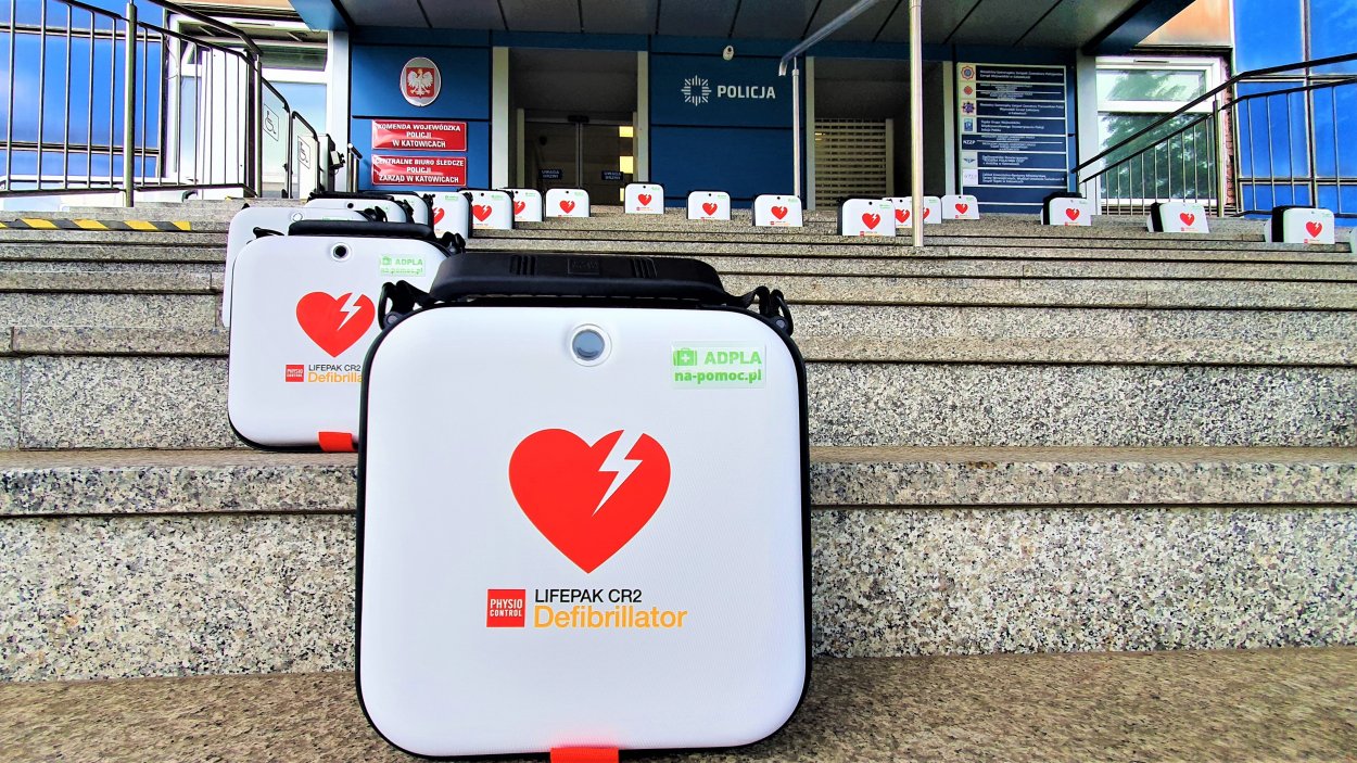 Defibrylatory ustawione w kształt serce na schodach przed wejściem do Komendy Wojewódzkiej Policji w Katowicach.